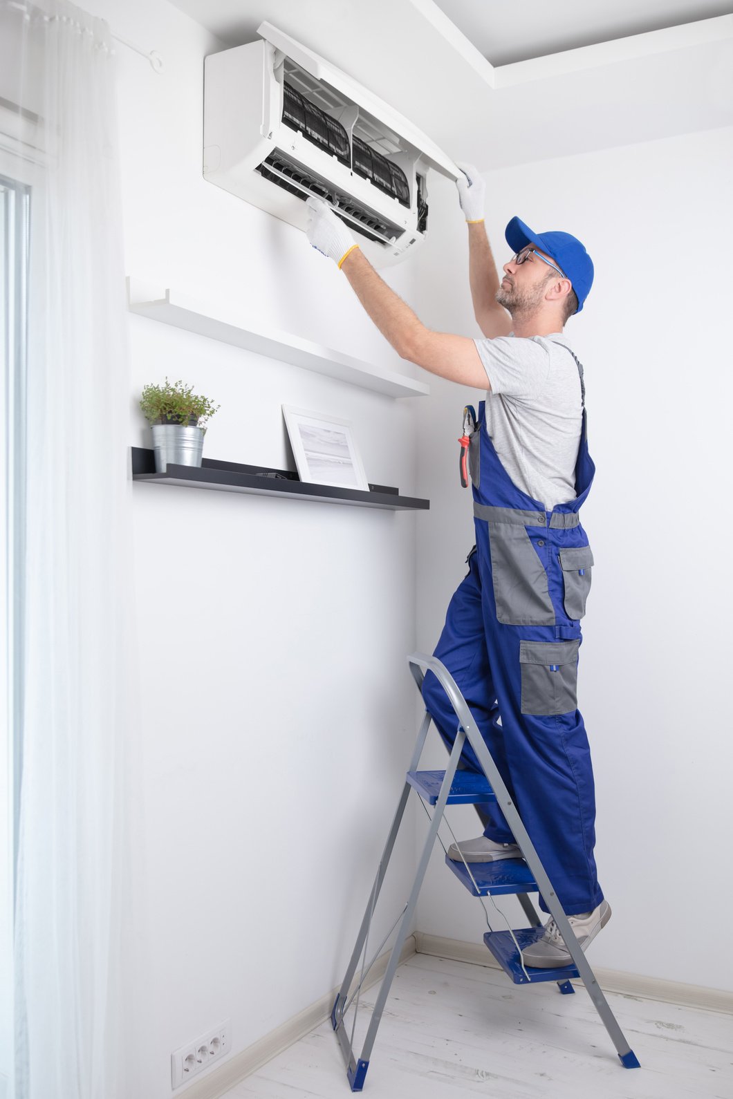 Service guy cleaning and maintaining air condition unit.